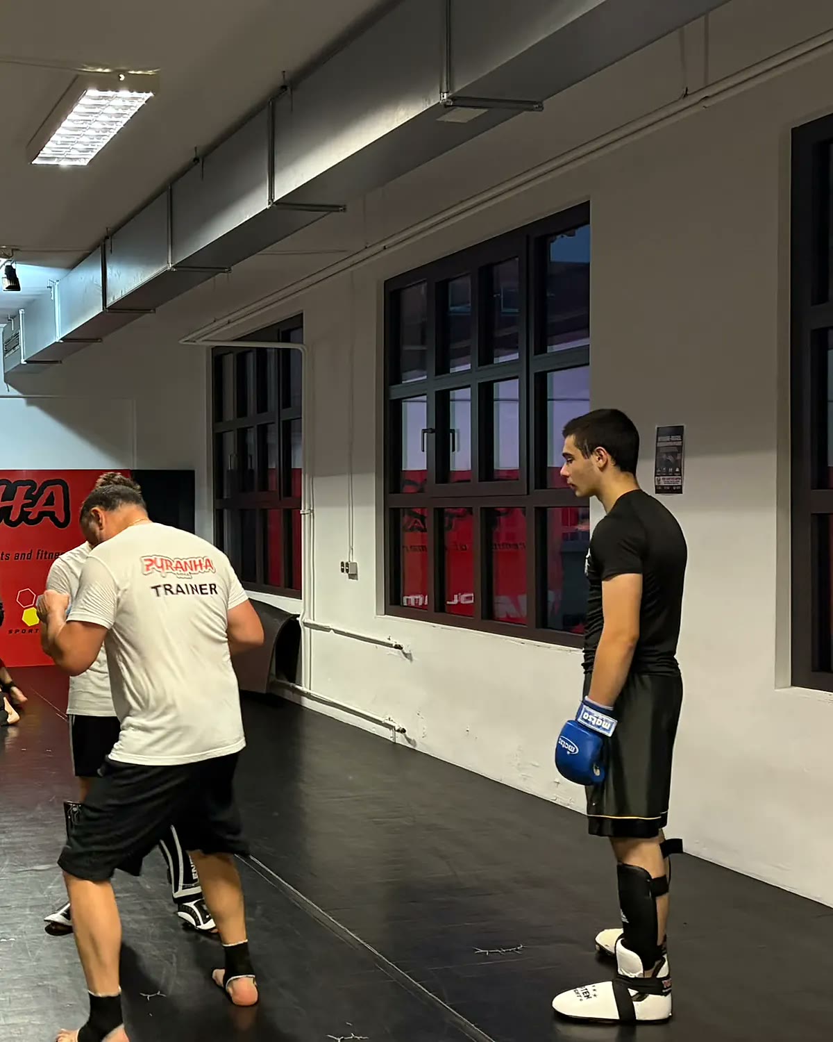 Junior Pyranha mit Boxhandschuhen und Trainer